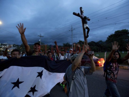 Un migrante hondureño sostiene una réplica del Cristo Negro de Esquipulas como una caravana de migrantes que se dirigen a los Estados Unidos. llega a Esquipulas, Guatemala, el lunes 15 de octubre de 2018. Foto: Agencia AP.