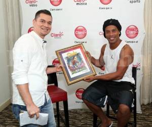 El periodista de Zona Deportiva de EL HERALDO, Alexeiv Morales, entrega de parte del diario una caricatura elaborada por Manuel Rodríguez al astro Ronaldinho. Foto: Marvin Salgado / EL HERALDO.