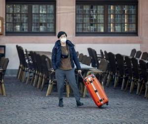 Una turista asiática recorre la plaza Roemerberg en Fráncfort, Alemania. Más de 120 que estaban en cuarentena fueron dados de alta finalmente. Foto: AP.