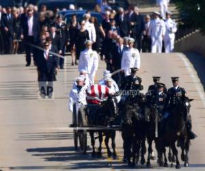 Familiares, incluida Cindy McCain, centro atrás, siguen una cureña tirada por caballos que transporta el féretro del senador John McCain al cementerio de la Academia Naval de Estados Unidos en Annapolis, Maryland, domingo 2 de septiembre de 2018. McCain murió de un tumor cerebral el 25 de agosto. Tenía 81 años.