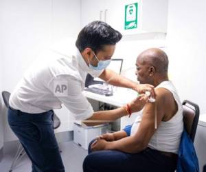 El farmacéutico Bhaveen Patel administra una dosis de la vacuna contra el COVID-19 de Oxford/AstraZeneca a Joshua Labor, en una clínica de vacunaciones en la Junction Pharmacy en Brixton, Londres. Foto:AP