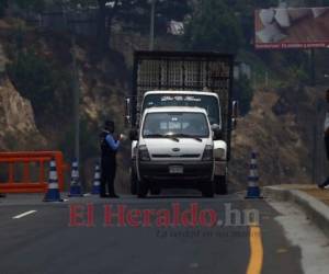 Un policía revisa la documentación de un vehículo que ingresaba a Tegucigalpa el domingo 26 de abril. La circulación está prohibida en Honduras, salvo para los empleados de las labores esenciales durante la emergencia contra el Covid-19. Foto: Emilio Flores / EL HERALDO.
