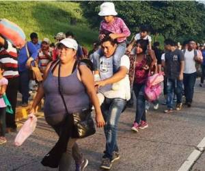 Honduran migrants taking part in a caravan heading to the US, queue to receive food during a stop in their journey, in Huixtla, Chiapas state, Mexico, on October 23, 2018. - Thousands of mainly Honduran migrants heading to the United States -- a caravan President Donald Trump has called an 'assault on our country' -- stopped to rest Tuesday after walking for two days into Mexican territory. (Photo by Johan ORDONEZ / AFP)