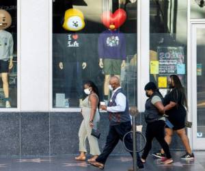 Personas con mascarillas caminan frente a una tienda en Hollywood Boulevard en medio de la pandemia de coronavirus, 16 de noviembre de 2020 en Hollywood, California. Foto: Agencia AFP.
