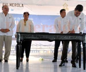 Momento en el que firma el contrato el mandatario hondureño, atrás está el representante de EMCO y el director de INSEP.