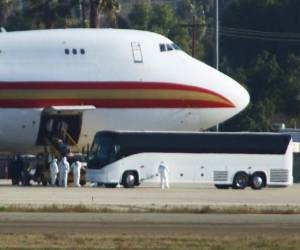 El personal en trajes de riesgo biológico espera a los pasajeros evacuados de Wuhan. Foto AFP