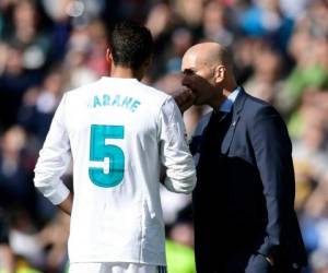 Zinedine Zidane mientras conversa con el francés Raphael Varane. (AFP)