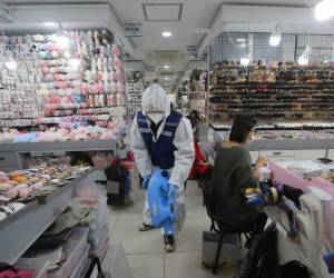 Un trabajador de salud rocía desinfectante en una tienda como precaución contra el nuevo coronavirus, en esta fotografía de archivo del 5 de febrero de 2020, en el mercado Namdaemun de Seúl.