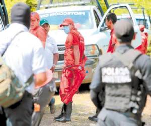 Forenses y policías trabajan en la zona donde están las fosas.