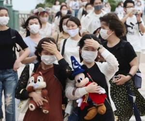 Los visitantes, muchos con coloridos trajes de Disney, debían llevar mascarillas obligatorias y someterse a chequeos de temperatura.
