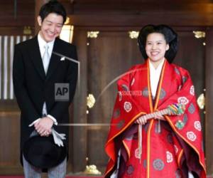 La princesa japonesa Ayako, a la derecha, vestida con una túnica ceremonial tradicional, y el novio Kei Moriya, a la izquierda, hablan con los periodistas después de su ceremonia de boda en el Santuario Meiji en Tokio, el lunes 29 de octubre de 2018.