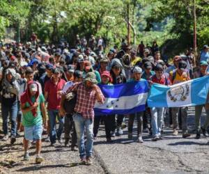 Migrantes hondureños participan en una nueva caravana que se dirige a los Estados Unidos con banderas nacionales hondureñas y guatemaltecas en Quezaltepeque, Chiquimula, Guatemala, el 22 de octubre de 2018.