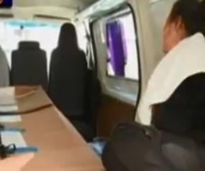 La madre junto al féretro en el que se encuentra el cuerpo de su hijo asesinado en México.