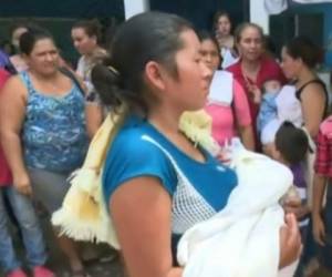 La madre de la menor de siete meses la sostiene en sus brazos antes de reingresarla al Mario Catarino Rivas.