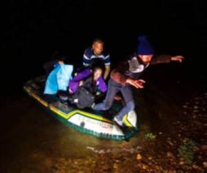 Migrantes desembarcan de un bote inflable con el que cruzaron el río Bravo cerca de Roma, Texas. Foto: AP