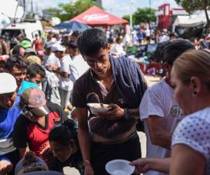 Honduran migrants taking part in a caravan heading to the US, queue to receive food during a stop in their journey, in Huixtla, Chiapas state, Mexico, on October 23, 2018. - Thousands of mainly Honduran migrants heading to the United States -- a caravan President Donald Trump has called an 'assault on our country' -- stopped to rest Tuesday after walking for two days into Mexican territory. (Photo by Johan ORDONEZ / AFP)