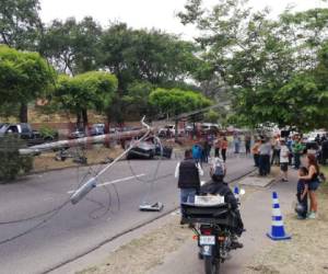 Un poste de tendido eléctrico cedió tras el fuerte impacto del conductor, quien murió tras ser asaltado en el bulevar Fuerzas Armadas. (Fotos: Estalin Irías / EL HERALDO)