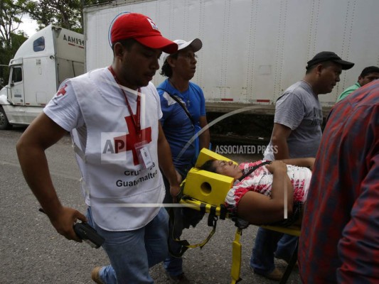 Una trabajadora migratoria hondureña débil recibe ayuda de trabajadores de la Cruz Roja Guatemalteca, mientras que una caravana de migrantes hondureños está bloqueada en la frontera con Honduras que se conecta con Agua Caliente, Guatemala. Agencia AFP.