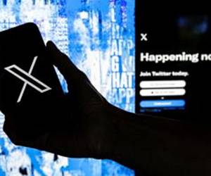 Fotografía de archivo que muestra a un usuario mientras sostiene un teléfono móvil que muestra el logotipo 'X' frente a la página principal de Twitter, en Los Ángeles, California (EE.UU.). EFE/EPA/ETIENNE LAURENT