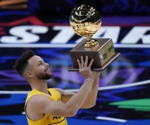 Stephen Curry, de los Warriors de Golden State, alza el trofeo después de ganar el concurso de triples en el marco del Juego de Estrellas de la NBA en Atlanta, el domingo 7 de marzo de 2021. Foto:AP
