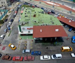 Conductores de automóviles hacen fila para llenar sus tanques en una gasolinera de La Habana. Foto AFP