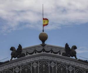 Una bandera española, que ondea a media asta en el inicio del luto oficial por las víctimas del Covid-19, sobre la cúpula de la estación de trenes de Atocha, en Madrid. Foto: AP.