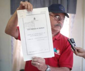 Mario Beltrán Amador, encargado del INA en la zona, muestra un título de propiedad otorgado a uno de los beneficiarios.