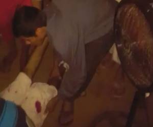 Momento en el que uno de los hombres asesinados es llevado a una vivienda. Foto: Captura