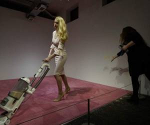 Una espectadora lanza migajas de pan para que una modelo que personifica a Ivanka Trump las aspire en la exposición de arte titulada 'Ivanka aspirando 2019'. (Foto: AP)