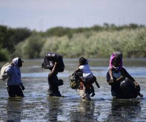 Los migrantes haitianos cargan sus pertenencias mientras cruzan el río Grande, visto desde Ciudad Acuña, estado de Coahuila, México, el 23 de septiembre de 2021. Foto: AFP