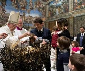 Francisco hizo el signo de la cruz en la frente de cada niño y ayudó a los hermanos mayores a hacer lo mismo con sus hermanos. Foto: AP