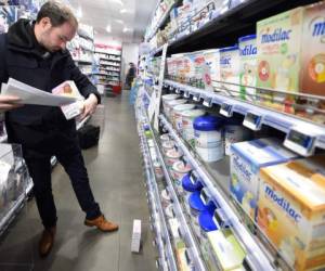 Un trabajador del Gobierno francés inspecciona productos de Lactalis en una farmacia. Foto AFP