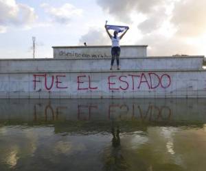 Un manifestante enmascarado alza una bandera durante una protesta contra el gobierno del presidente Daniel Ortega en Managua, Nicaragua. Se han presentado 18 testigos que dicen haber sufrido torturas y abuso sexual a manos de las fuerzas represivas, ante un panel de abogados y psicólogos en San José, Costa Rica. Foto: AP.