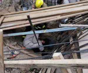 Miembros del Cuerpo de Bomberos intentan rescatar al obrero. Foto:EL HERALDO.