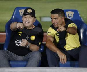 El ex astro argentino Diego Maradona, izquierda, actual técnico de los Dorados de Sinaloa, dialoga con un miembro del cuerpo técnico del club al inicio del partido de los cuartos de final de la Copa MX ante los Pumas de la UNAM, en el Estadio Olímpico Universitario en Ciudad de México.