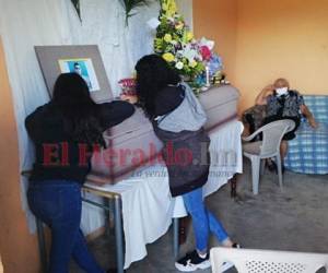 Personas lloran sobre el ataúd de una de las víctimas del fatal incidente en la aldea Nueva Suyapa de Tegucigalpa. Foto: Estalin Irías/ EL HERALDO.