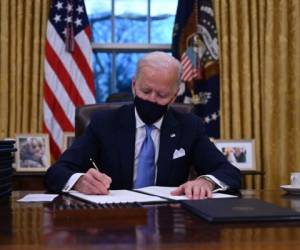 El presidente de los Estados Unidos, Joe Biden, se sienta en la Oficina Oval mientras firma una serie de órdenes en la Casa Blanca en Washington, DC. Foto: AFP
