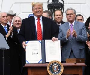 El mandatario mostró el documento firmado y celebró el tratado entre los países de norteamérica. Foto: AFP.