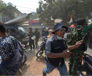 Un soldado indonesio y un funcionario intentan calmar a la población poco después de que una réplica azotara la zona de Tanjung, en Lombok. Foto AFP