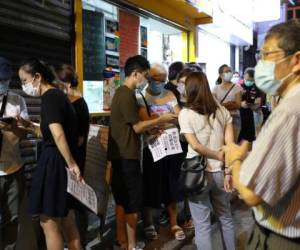 Los votantes hacen cola este sábado frente a un colegio electoral durante una elección primaria en Hong Kong.