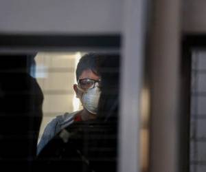 Un pasajero con una mascarilla usa un elevador antes de abordar un vuelo en el Aeropuerto Internacional Arturo Benítez en Santiago, Chile, 3 de marzo de 2020.