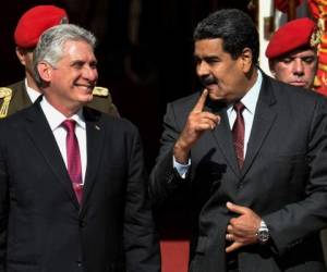 En esta foto de archivo tomada el 30 de mayo de 2018, el presidente cubano Miguel Díaz-Canel (L) y su homólogo venezolano Nicolás Maduro conversan durante una reunión en el Palacio Presidencial de Miraflores en Caracas.