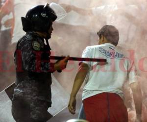 Miembros de las fuerzas de seguridad tratan de controlar a los barristas en las gradas del estadio Nacional. Foto: David Romero / El Heraldo.