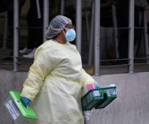 Un trabajador de la salud camina para atender a un paciente infectado con el nuevo coronavirus mientras lo transfieren a otro edificio después de que el Hospital General de Enfermedades del IGSS estuviera abarrotado de pacientes con covid-19, en la Ciudad de Guatemala. Foto: Agencia AFP.