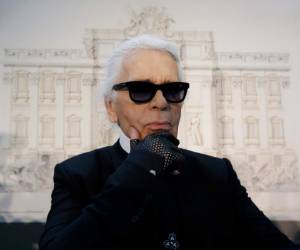 Fotografía de archivo del 14 de febrero de 2014 del diseñador de modas Karl Lagerfeld frente a sus libros antes de la inauguración de una exhibición en el museo Folkwang en Essen, Alemania.