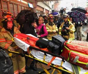 Los bomberos se preparan para llevar una camilla al edificio. Foto: Agencia AP.