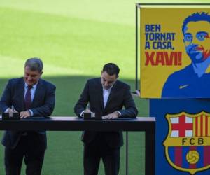Momento en que Xavi firmaba su contrato junto a Laporta. Foto: AFP