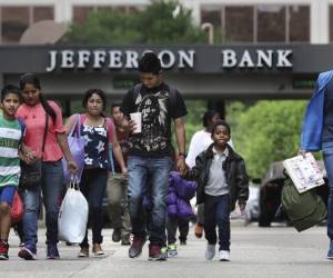 En este viernes, 29 de marzo de 2019, una foto, un voluntario de la Interfaith Welcome Coalition, a la derecha, dirige a un grupo de migrantes liberados de un centro de detención de Texas a la Iglesia Metodista de Travis Park después de dejarlos en la estación de autobuses de San Antonio. (Bob Owen / El San Antonio Express-News a través de AP)