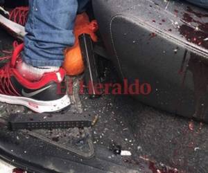 Una de las víctimas del triple crimen en San Pedro Sula, portaba un arma de fuego. El arma quedó a la par de su pie izquierdo en el interior del vehículo donde fueron asesinados.