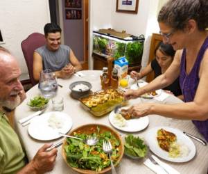 El inmigrante hondureño de 18 años que se hace llamar Fernando y que ha pedido asilo en Estados Unidos, sonríe mientras cena con la familia estadounidense que le ha acogido, cerca de Los Angeles, en California. Foto: AP